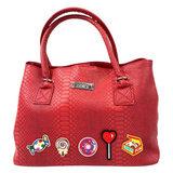 Donut Fun Doos Strijk Embleem Patch samen met andere snoepgoed patches op een rode tas