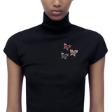 Broche Sierspeld Strass Vlinder Blauw samen met de rode en coffee gekleurde varianten op een zwart truitje met col