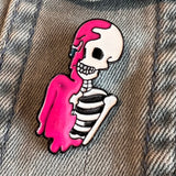 Close-Up van de Geraamte Skelet Emaille Pin Knal Roze op een ondergrond van spijkerstof