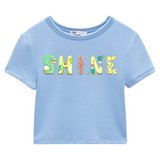 SHINE Tekst Strijk Applicatie op een lichtblauwe kort navelshirtje