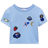 Aardbei Zomerkoninkje Fruit Strijk Embleem Patch samen met andere strijk patches op een lichtblauw t-shirt