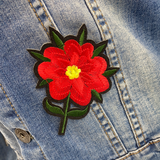 Close up van een Rode Bloem Op Steel Strijk Embleem Patch