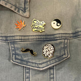 De Snor Krulsnor Moustache Emaille Pin samen met vier andere pins op een spijkerjasje