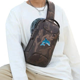 Cartoon dolfijn strijkpatch geborduurd voor kinderkleding en accessoires op een tasje met legerprint