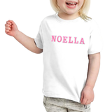 De naam Noella van de Alfabet Strijk Letter Embleem Patches Roze Wit op een wit t-shirtje