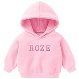 Het woord ROZE van de Alfabet Strijk Letter Embleem Patches Roze Wit op een kleine roze hoodie