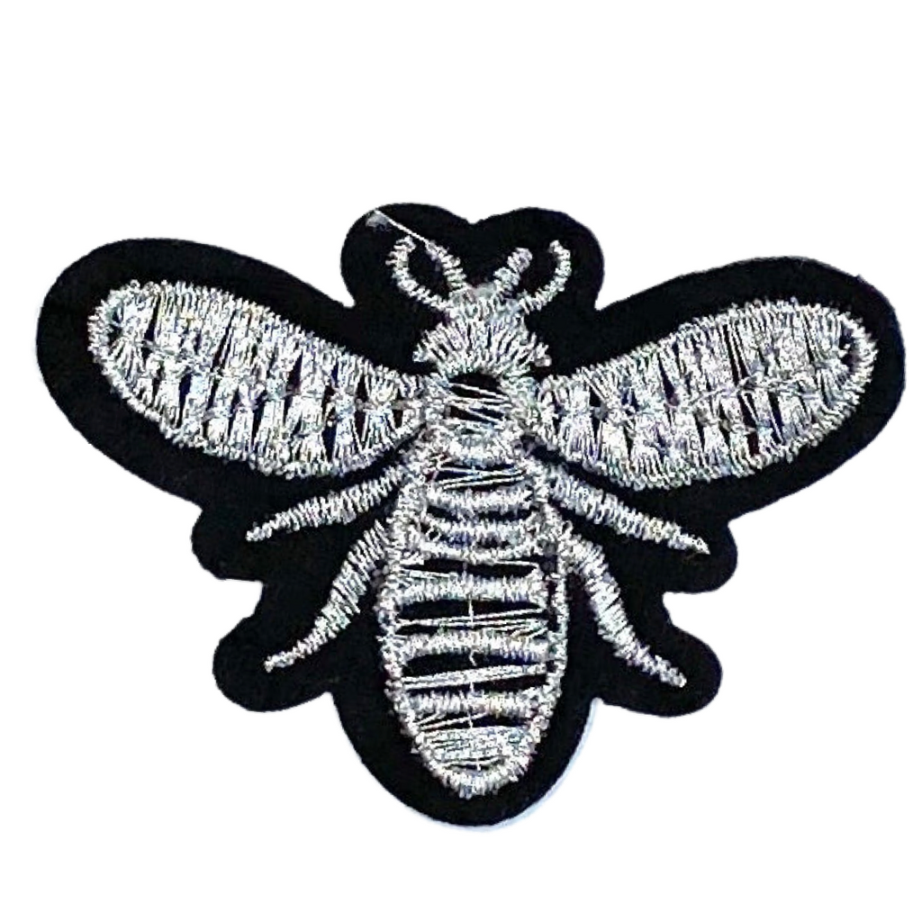 Strijkpatch van een zilverkleurig geborduurd bijtje op zwarte achtergrond